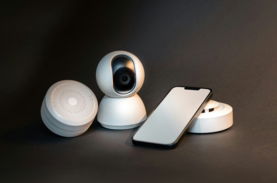 a smart phone sitting next to a wireless security camera